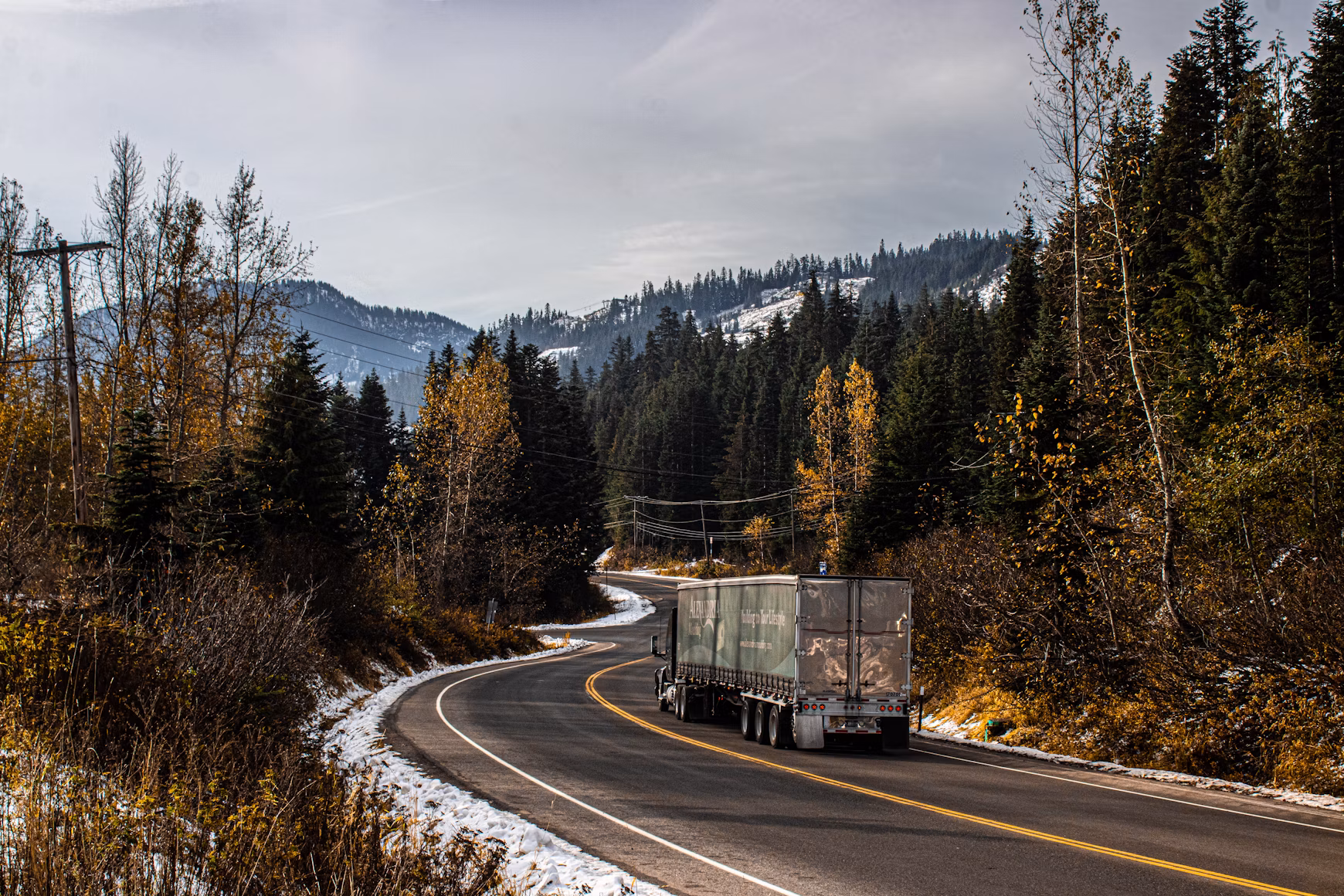 Semi-truck traveling along a wooded highway